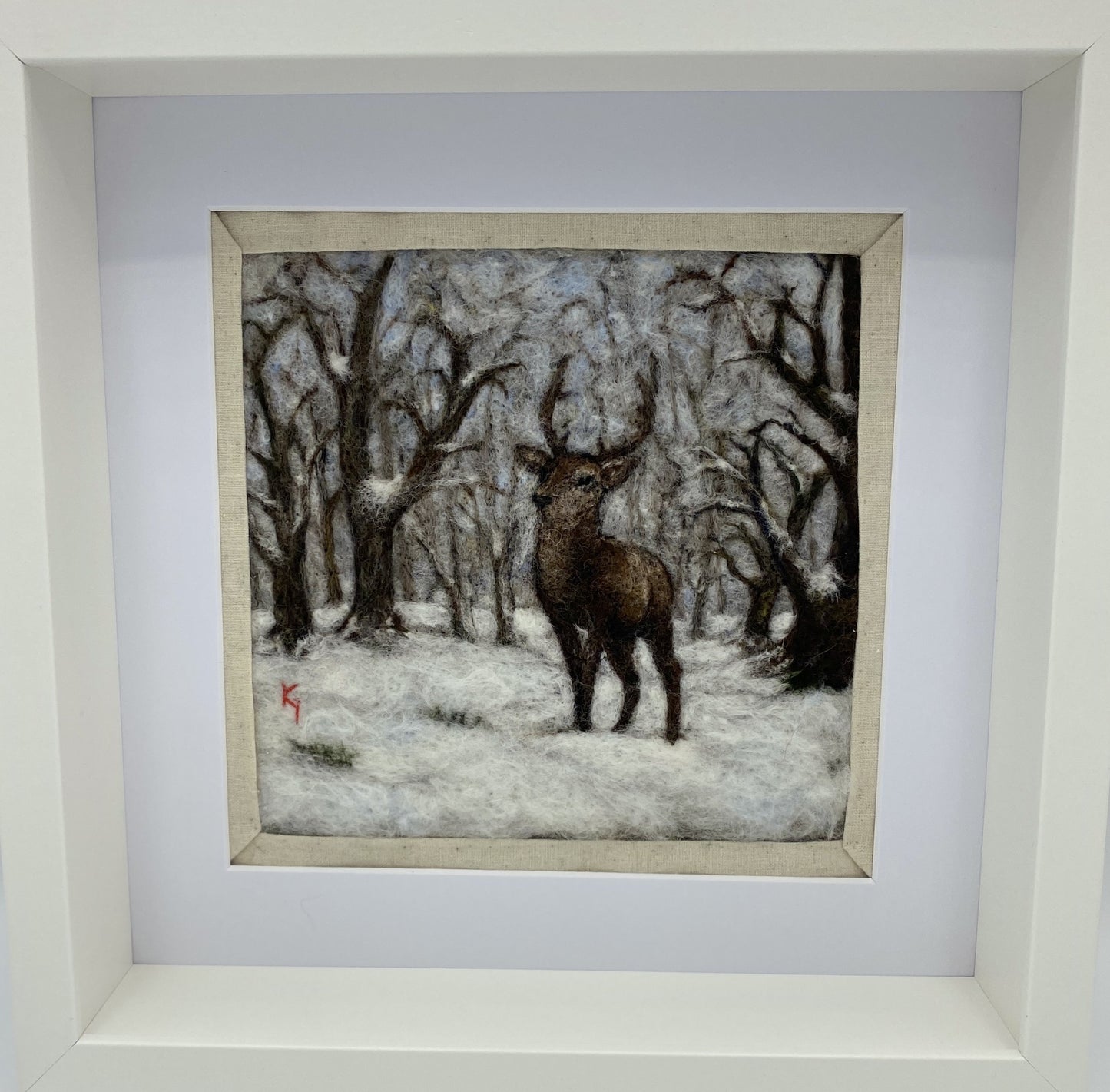 needle felted framed picture of a stag standing in woodland which is covered with fresh snow