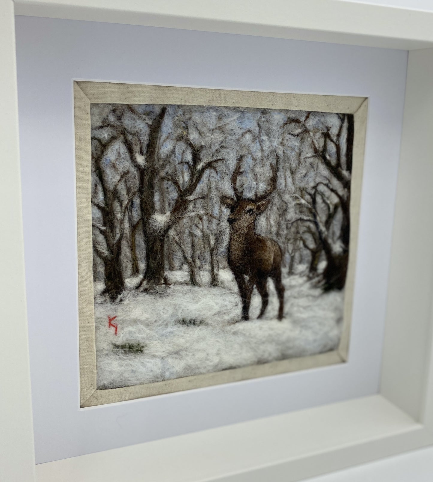 needle felted framed picture of a stag standing in woodland which is covered with fresh snow