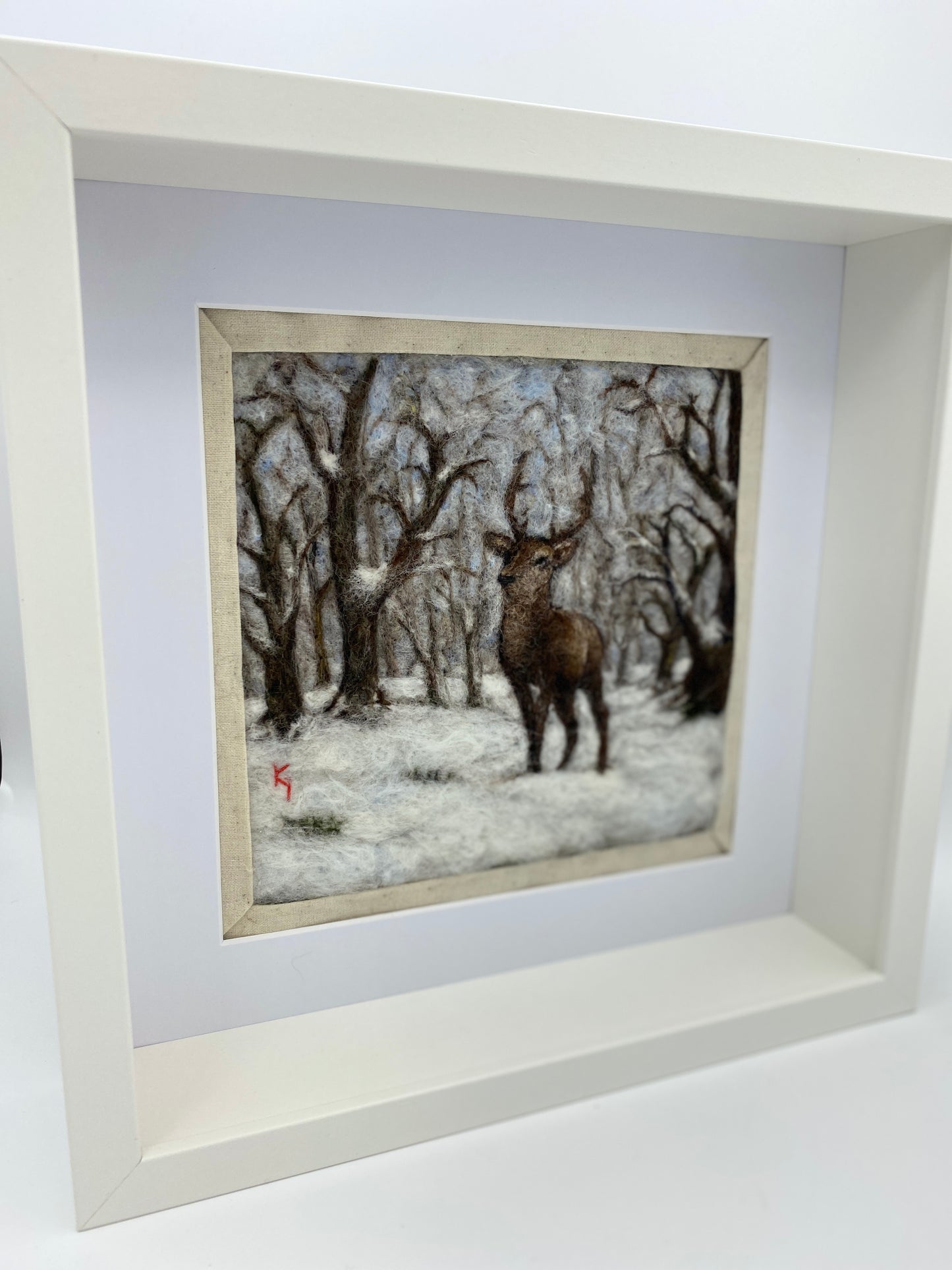 needle felted framed picture of a stag standing in woodland which is covered with fresh snow