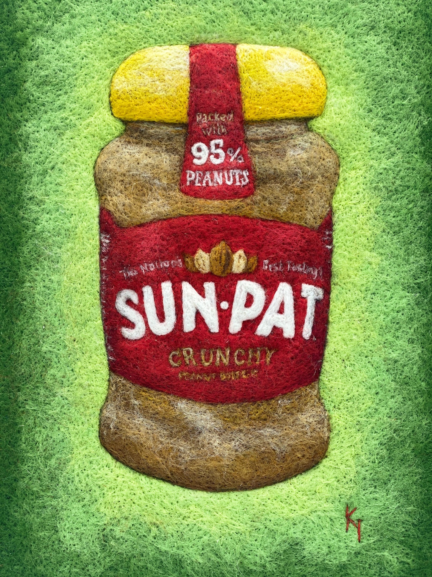 needle felted study of a jar of Sun-Pat peanut butter on a bright green background and framed in a white wooden box frame