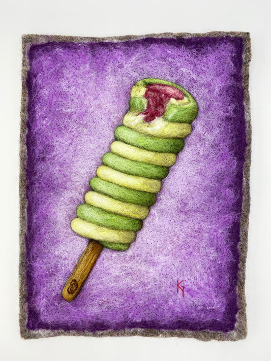 needle felted picture of a Twister ice lolly in green and yellow on a purple background