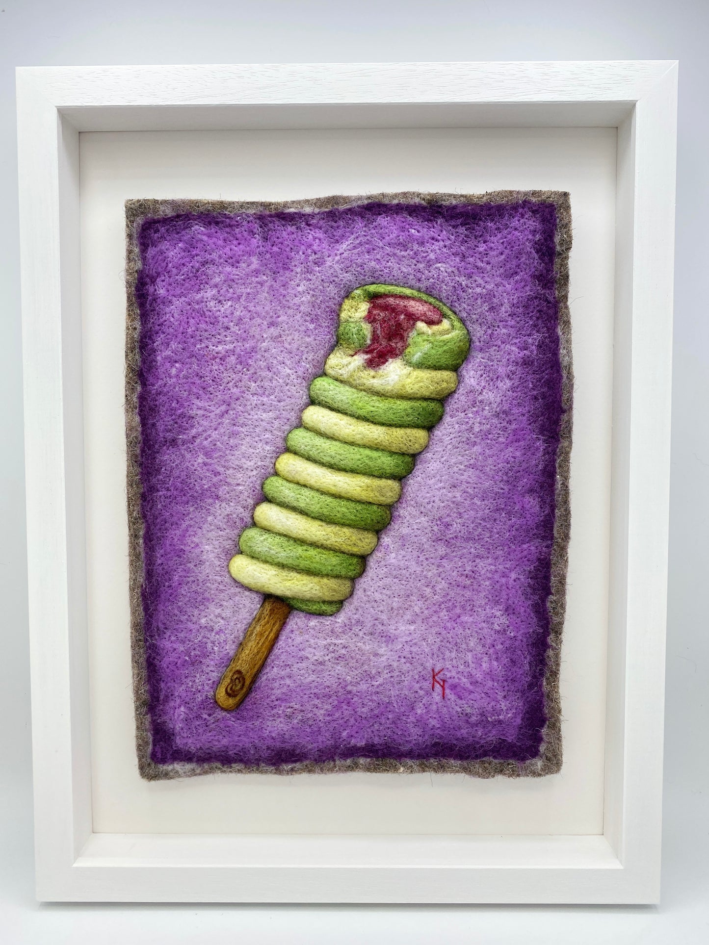 needle felted picture of a Twister ice lolly in green and yellow on a purple background