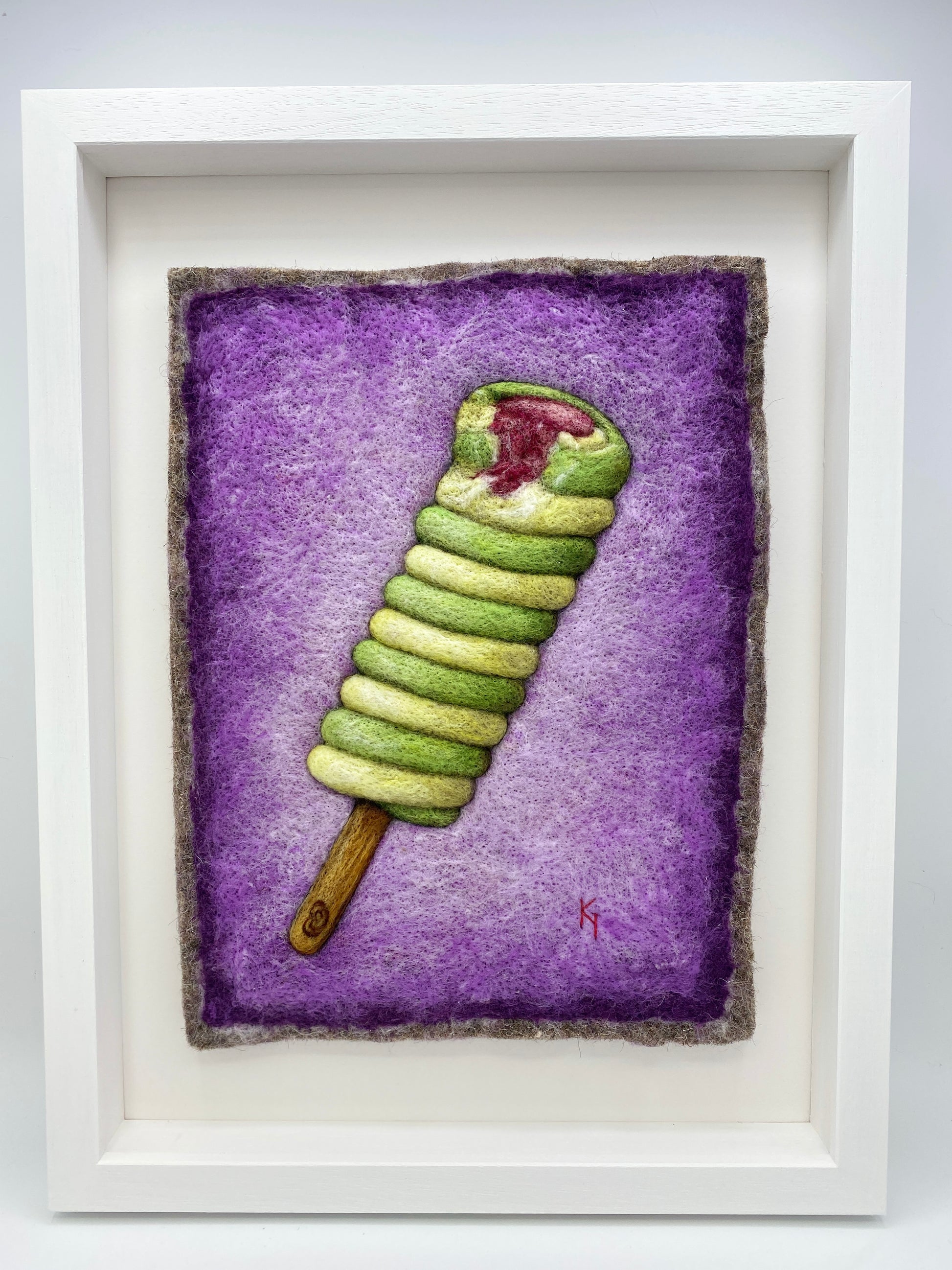 needle felted picture of a Twister ice lolly in green and yellow on a purple background