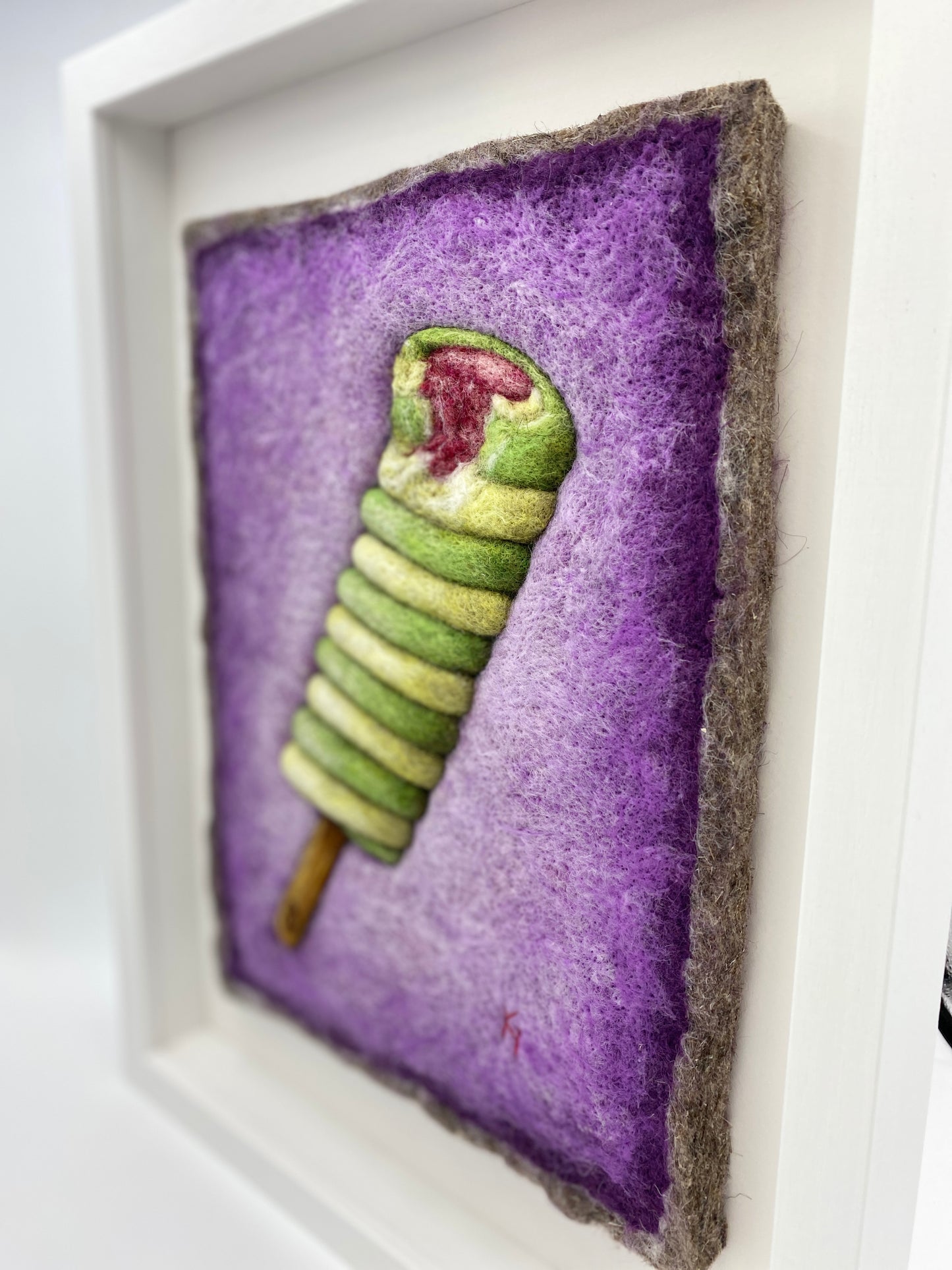 needle felted picture of a Twister ice lolly in green and yellow on a purple background