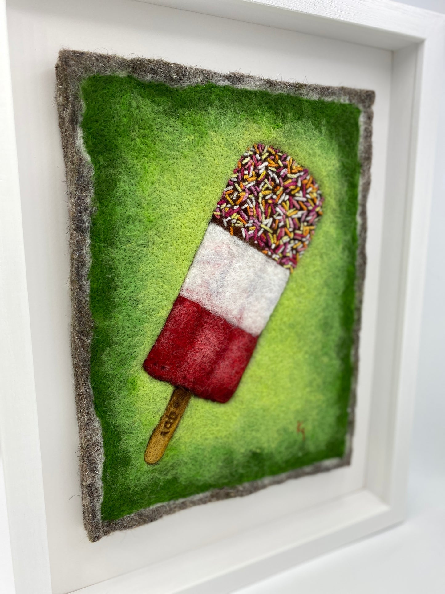 needle felted picture of a Fab ice lolly on a bright green background