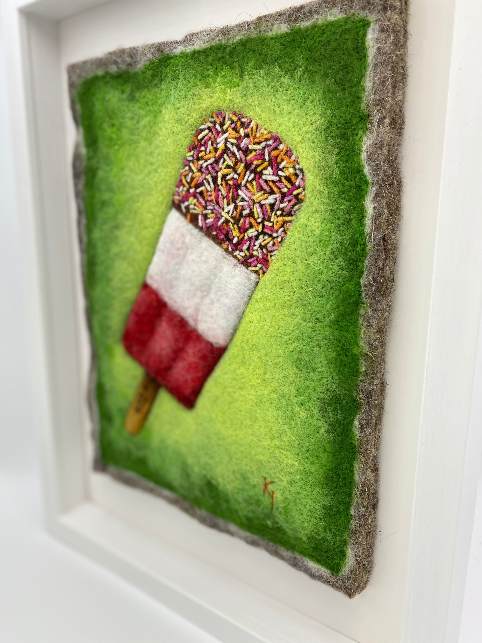 needle felted picture of a Fab ice lolly on a bright green background