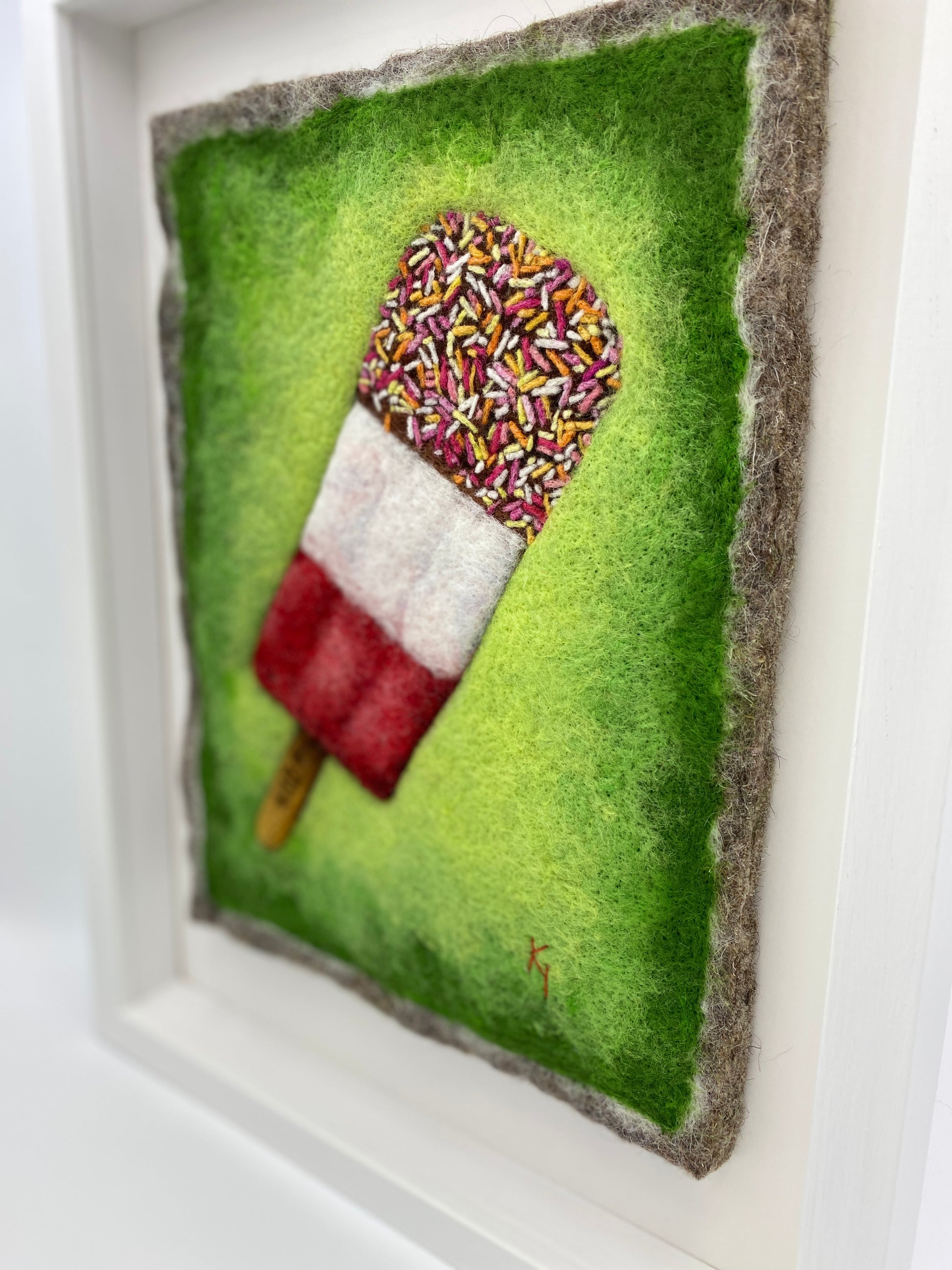 needle felted picture of a Fab ice lolly on a bright green background
