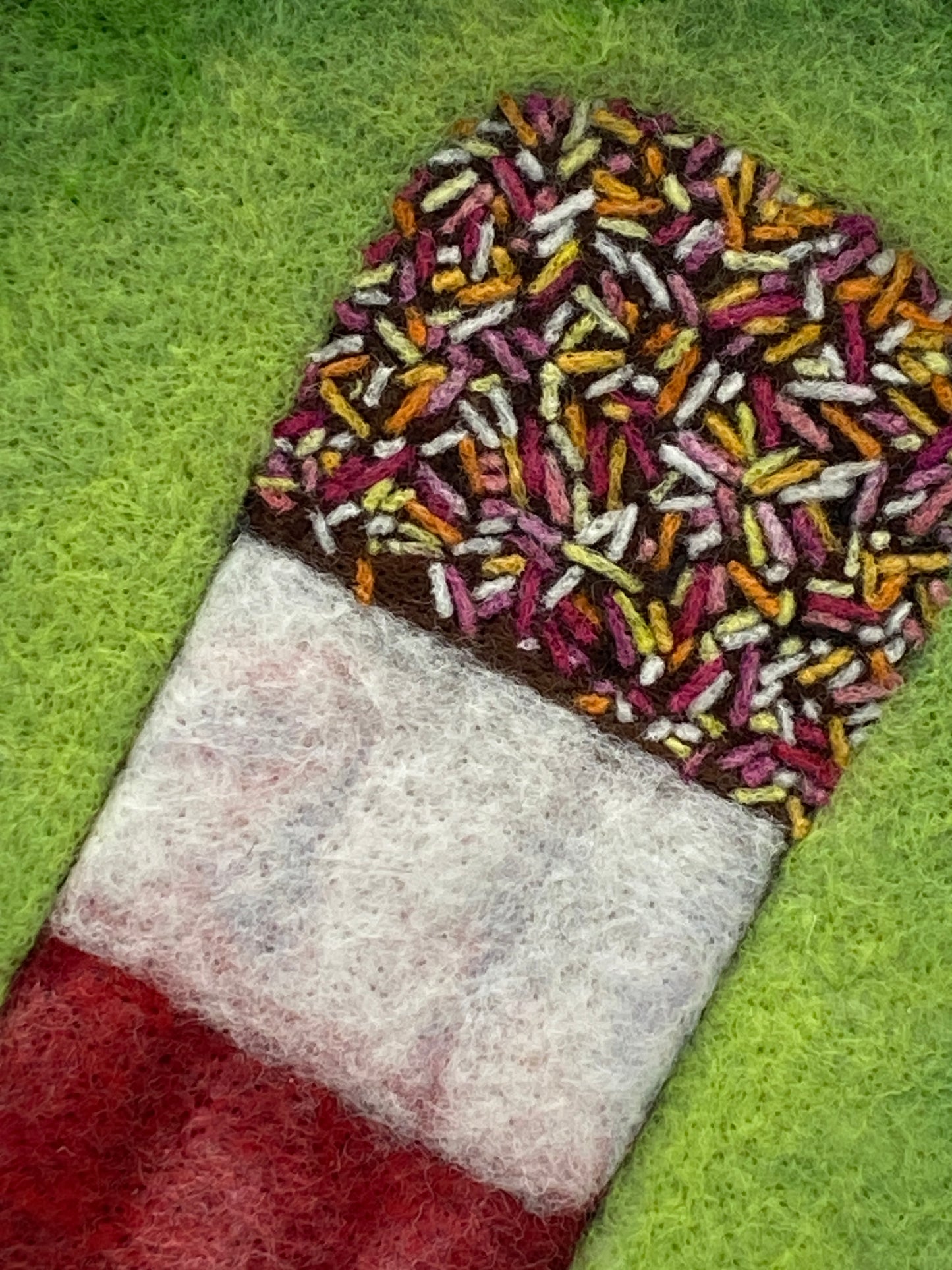 needle felted picture of a Fab ice lolly on a bright green background
