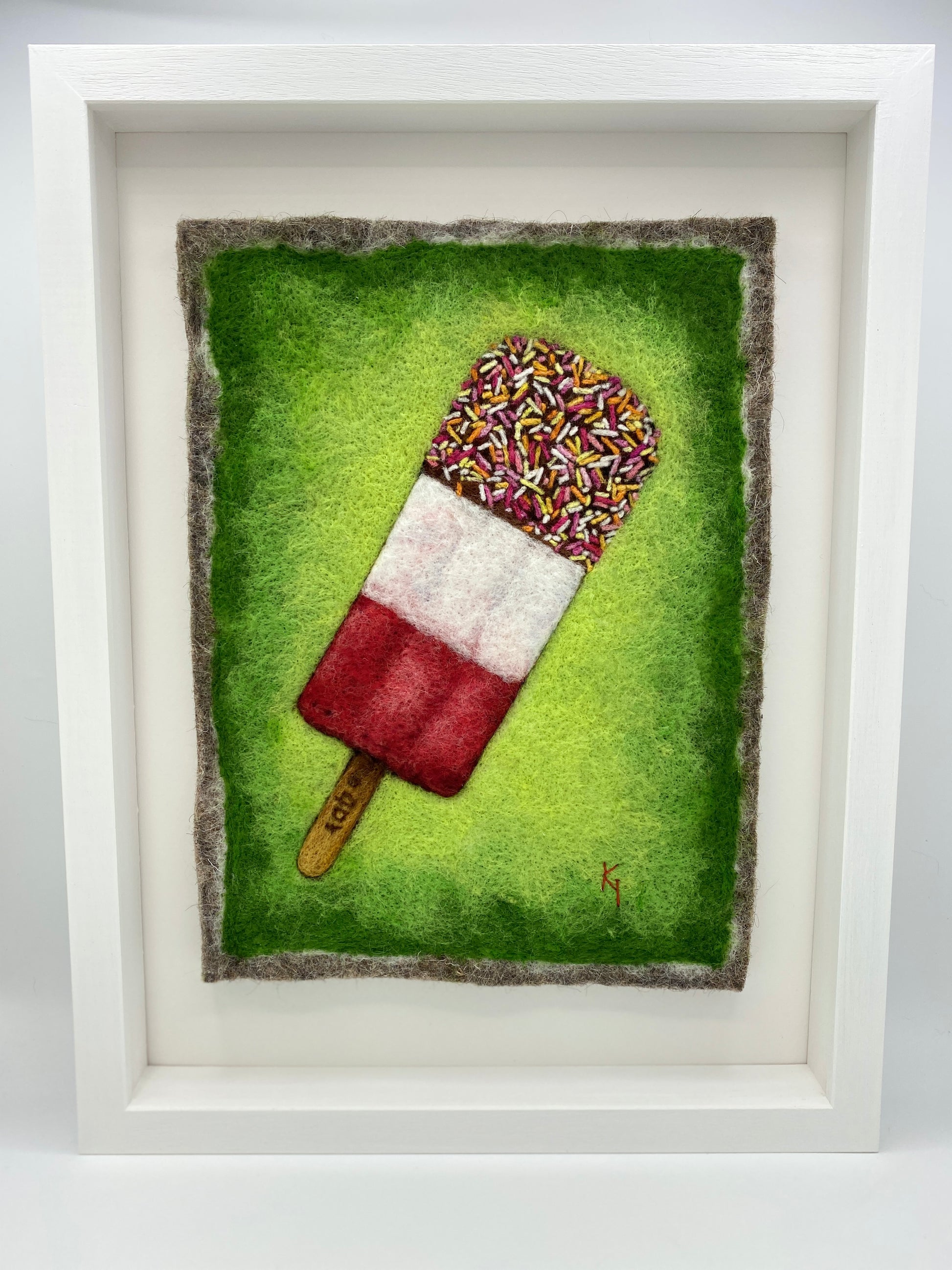 needle felted picture of a Fab ice lolly on a bright green background
