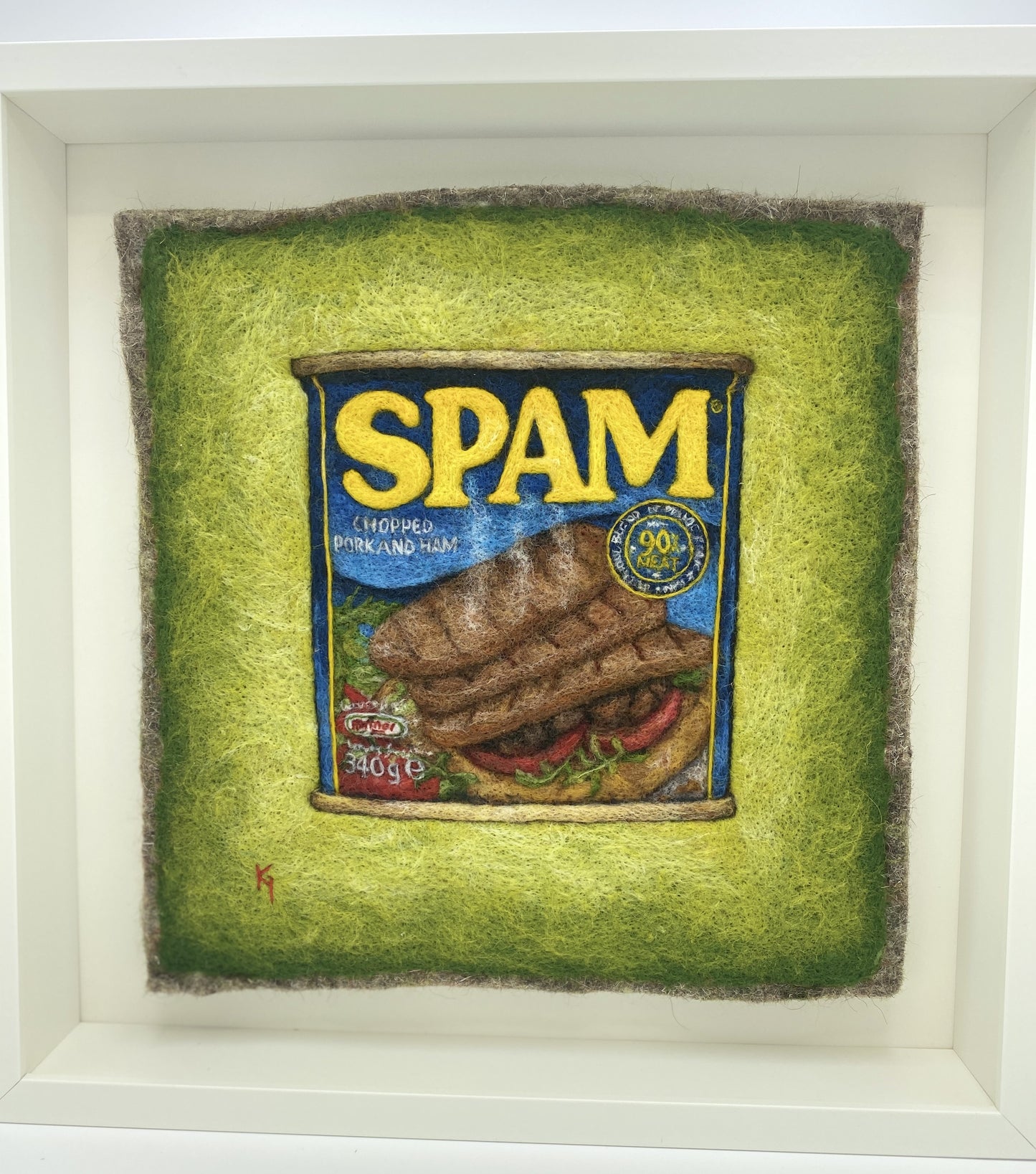 a needle felted picture of a can of Spam on a green background