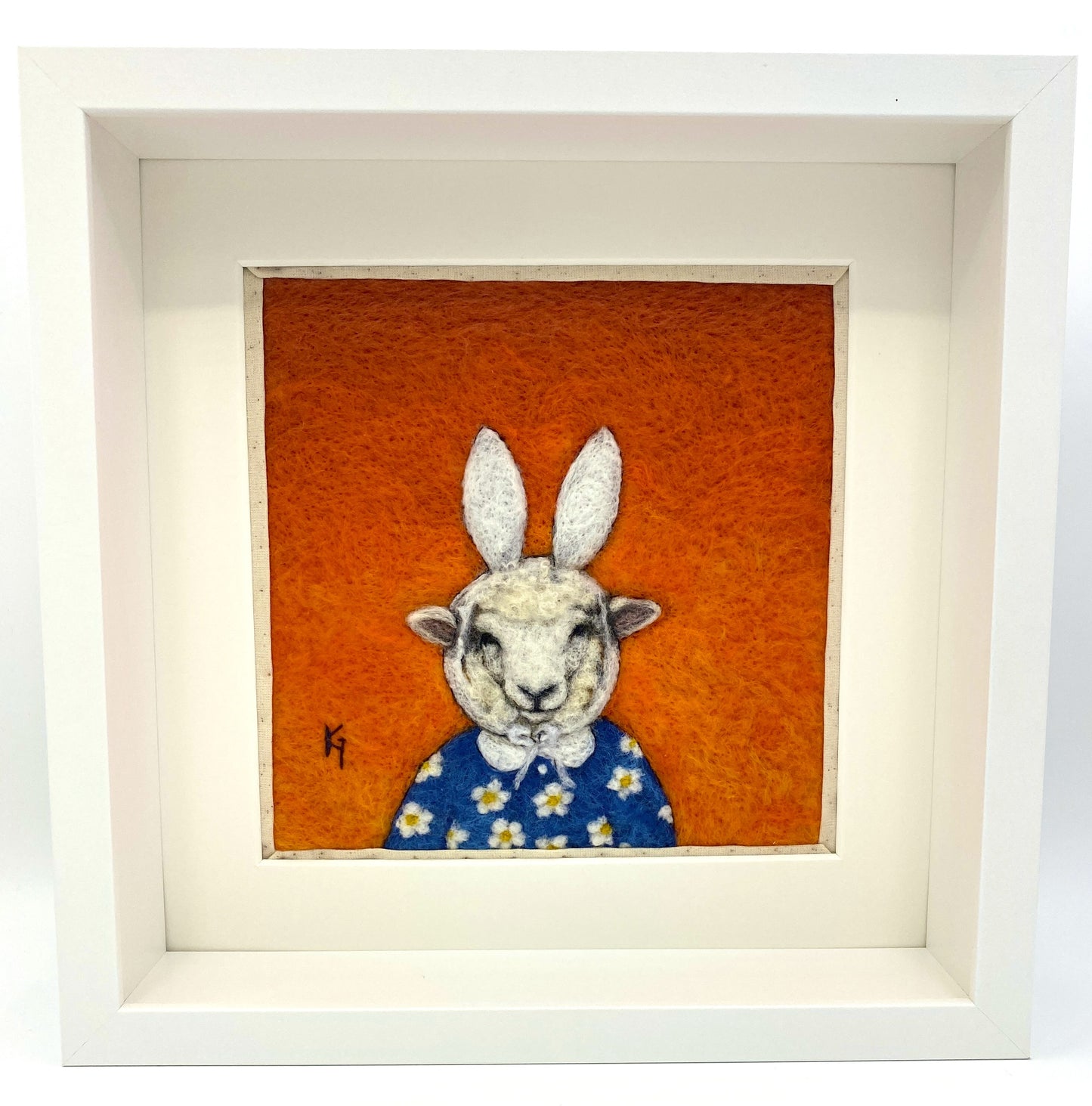 Needle felted picture of a sheep dressed as Miffy in her birthday dress, with an orange background