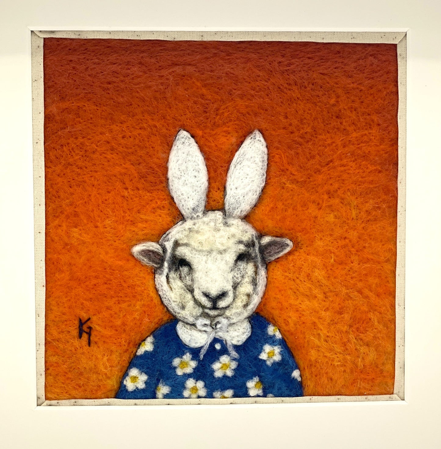 Needle felted picture of a sheep dressed as Miffy in her birthday dress, with an orange background