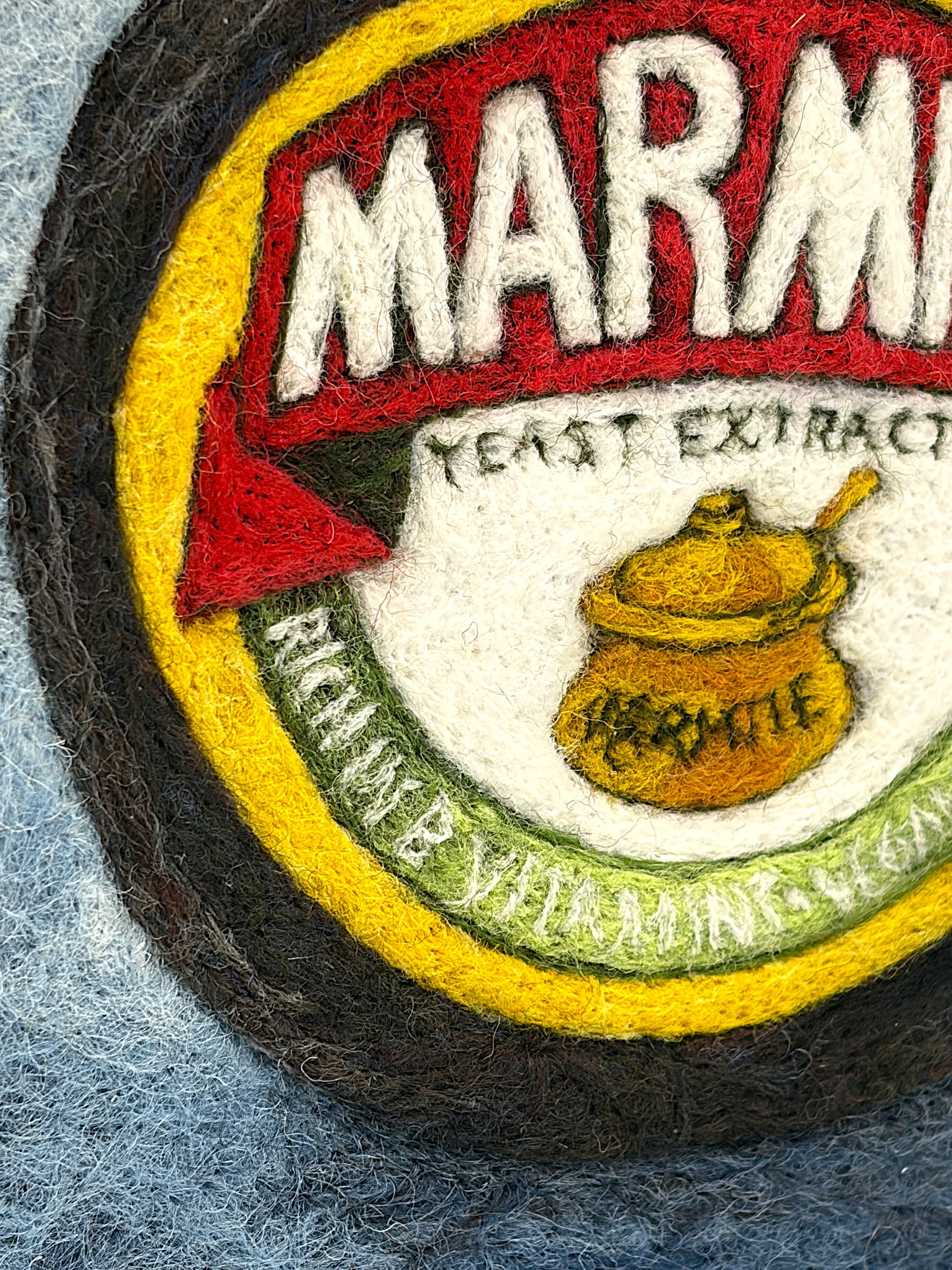 Needle felted framed picture of a pot of Marmite on a blue background