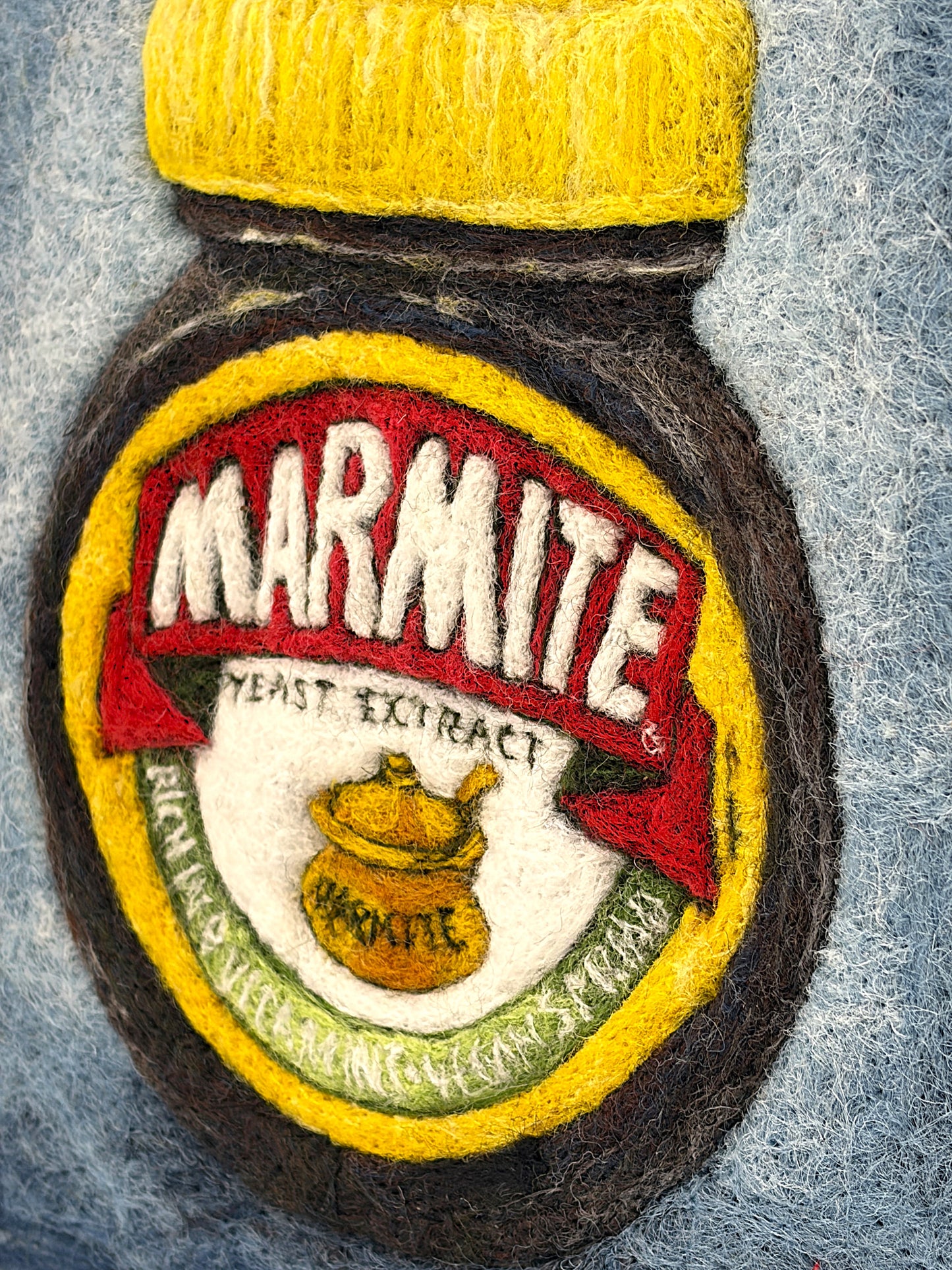 Needle felted framed picture of a pot of Marmite on a blue background