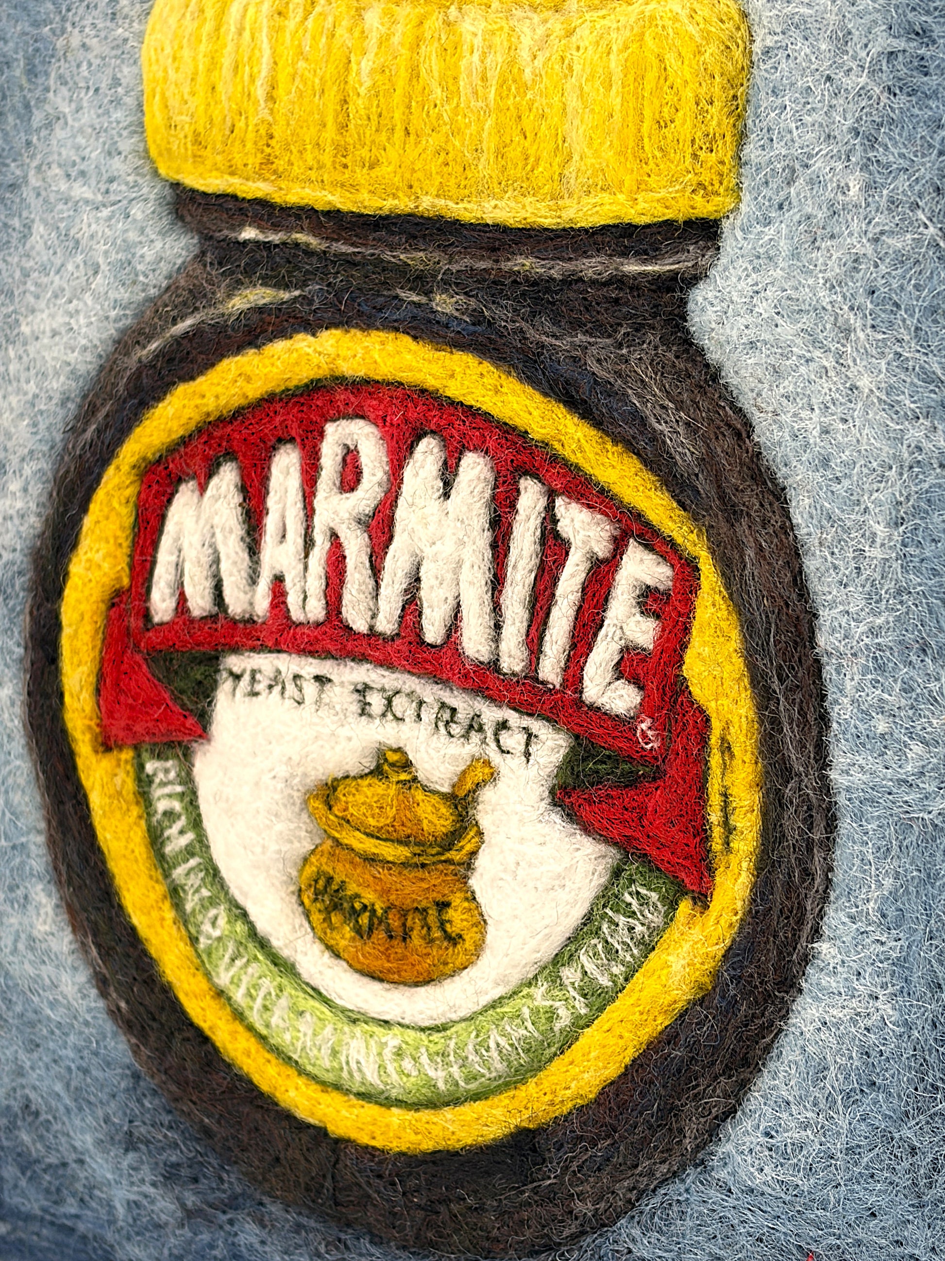 Needle felted framed picture of a pot of Marmite on a blue background