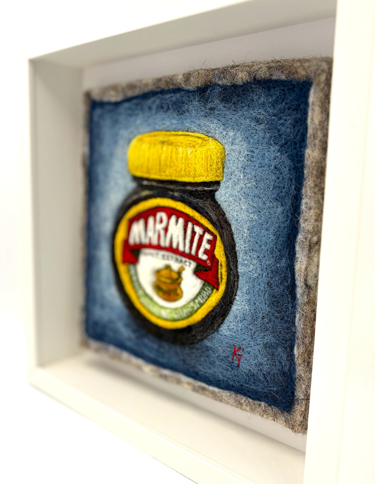 Needle felted framed picture of a pot of Marmite on a blue background