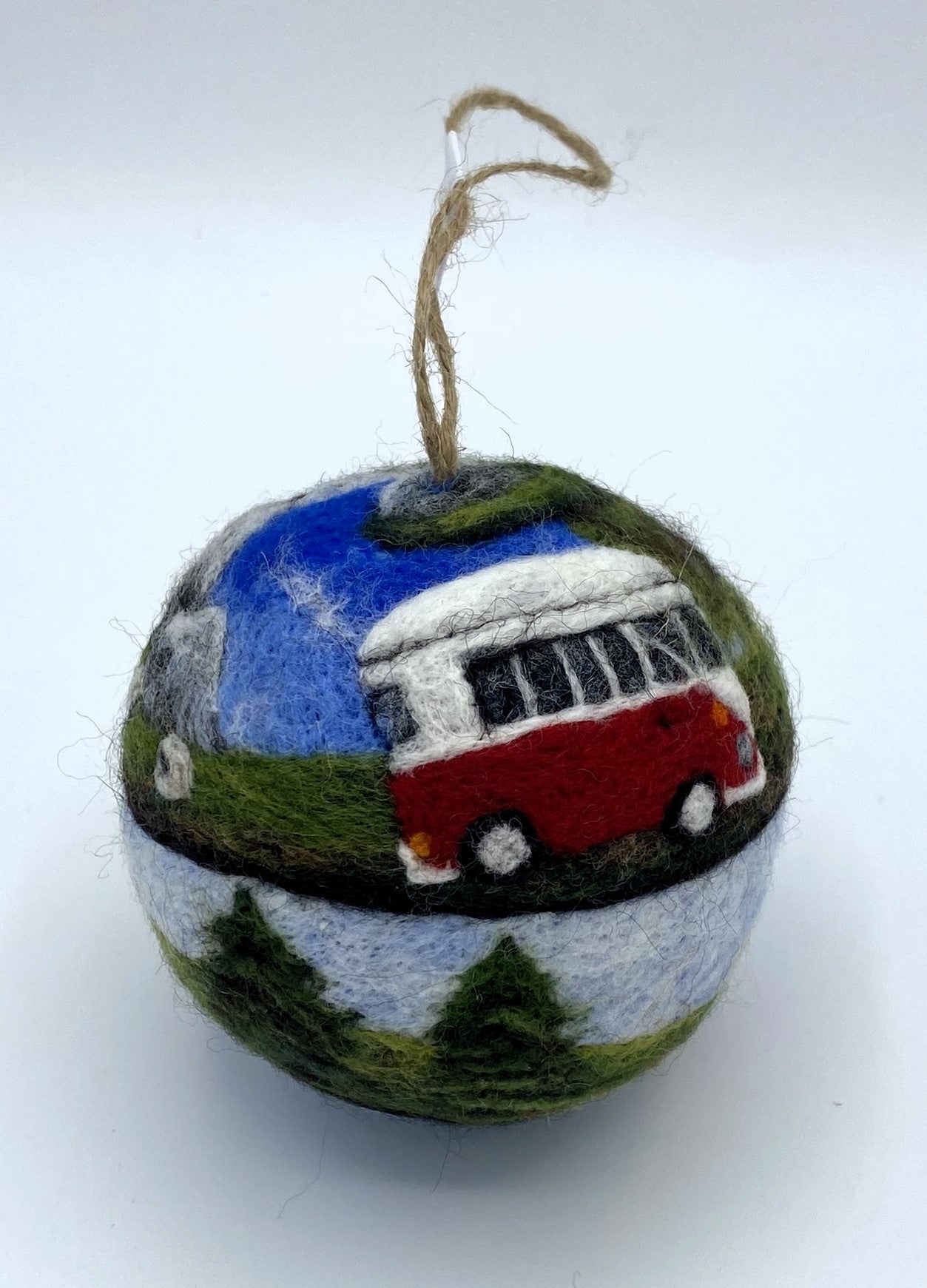 needle felted bauble depicting a camper van travelling through mountains, camping site and countryside and finally reaching the beach hut by the sea