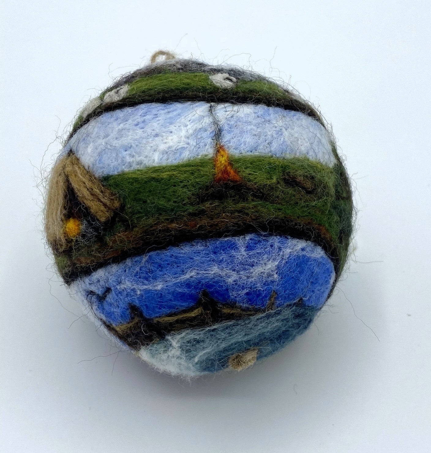 needle felted bauble depicting a camper van travelling through mountains, camping site and countryside and finally reaching the beach hut by the sea