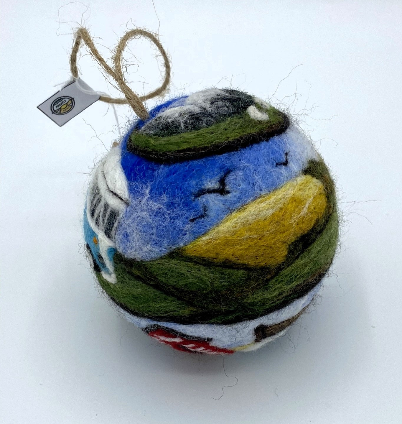 needle felted bauble depicting a camper van travelling through mountains, camping site and countryside and finally reaching the beach hut by the sea