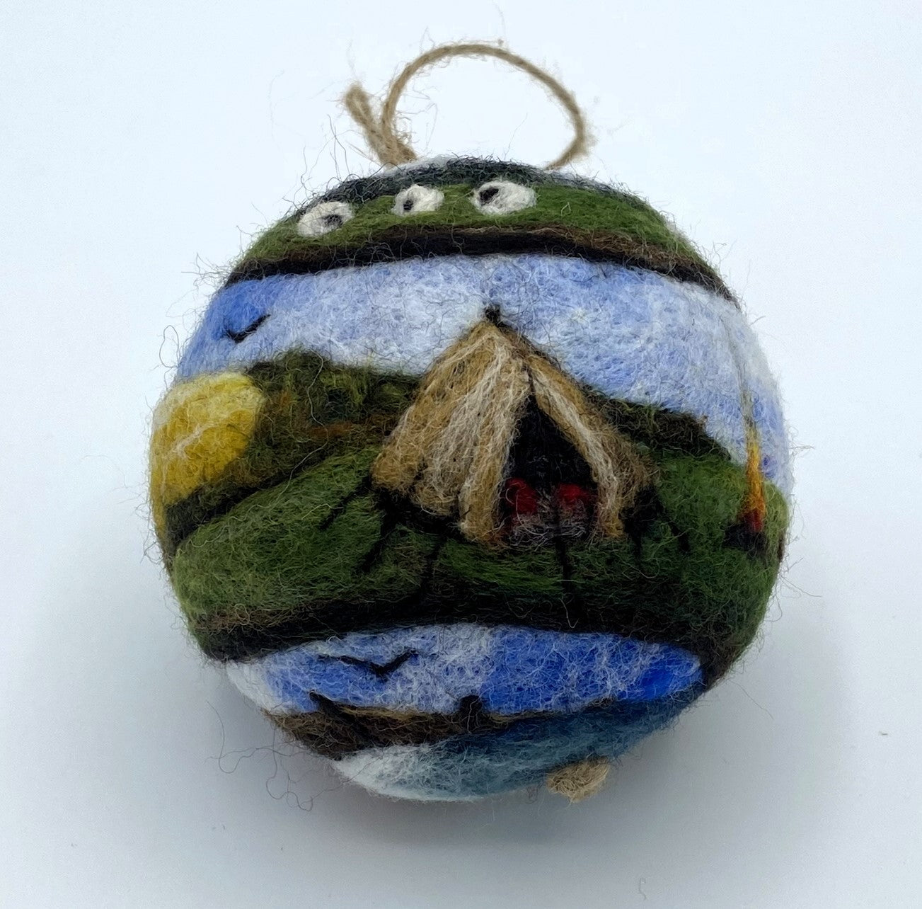 needle felted bauble depicting a camper van travelling through mountains, camping site and countryside and finally reaching the beach hut by the sea