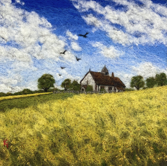 needle felted picture of a Medieval church in a field surrounded by yellow flowers with a blue sky above
