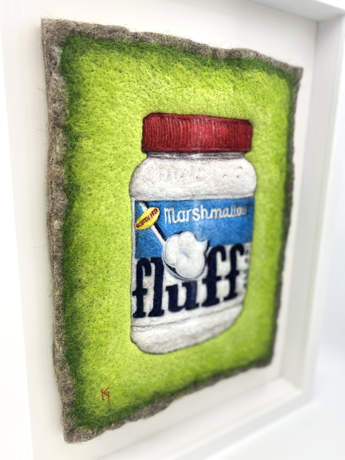 a needle felted picture of a jar of Fluff marshmallow spread, on a bright green background