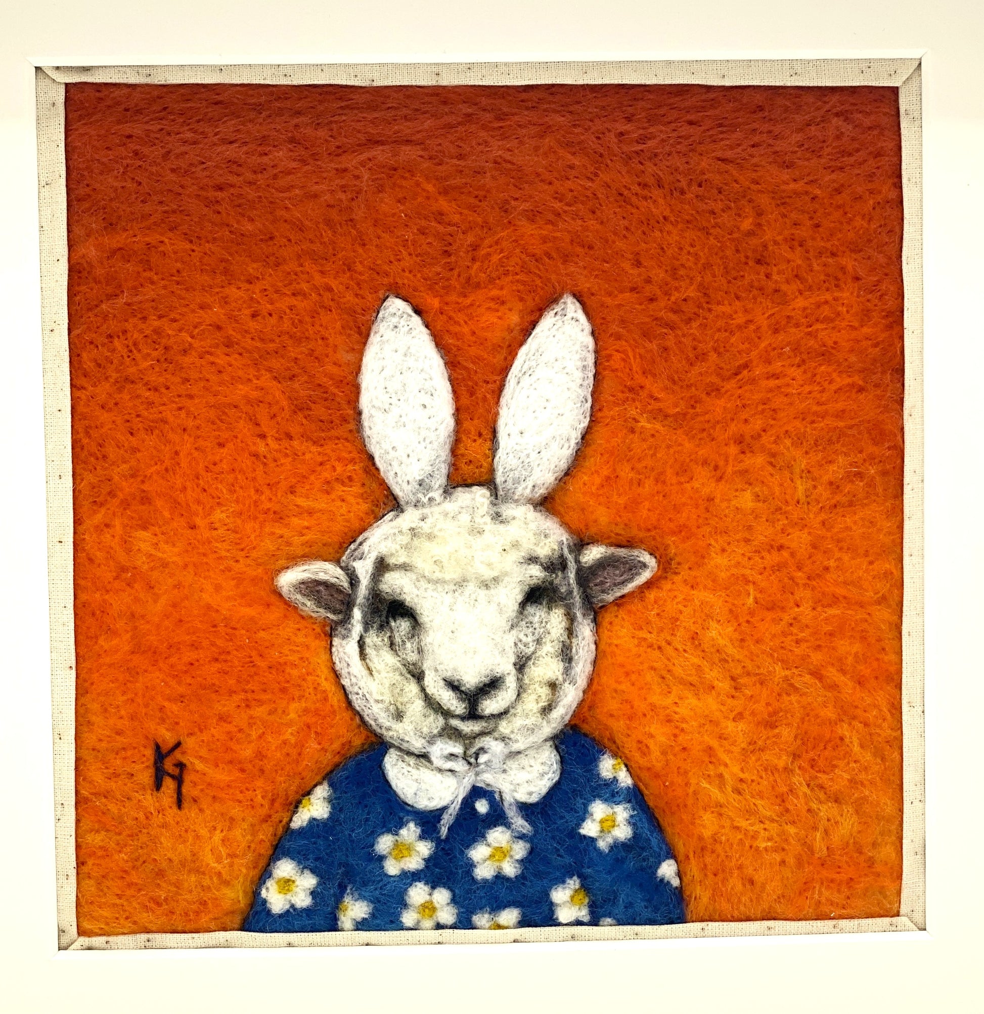 Needle felted picture of a sheep dressed as Miffy in her birthday dress, with an orange  background