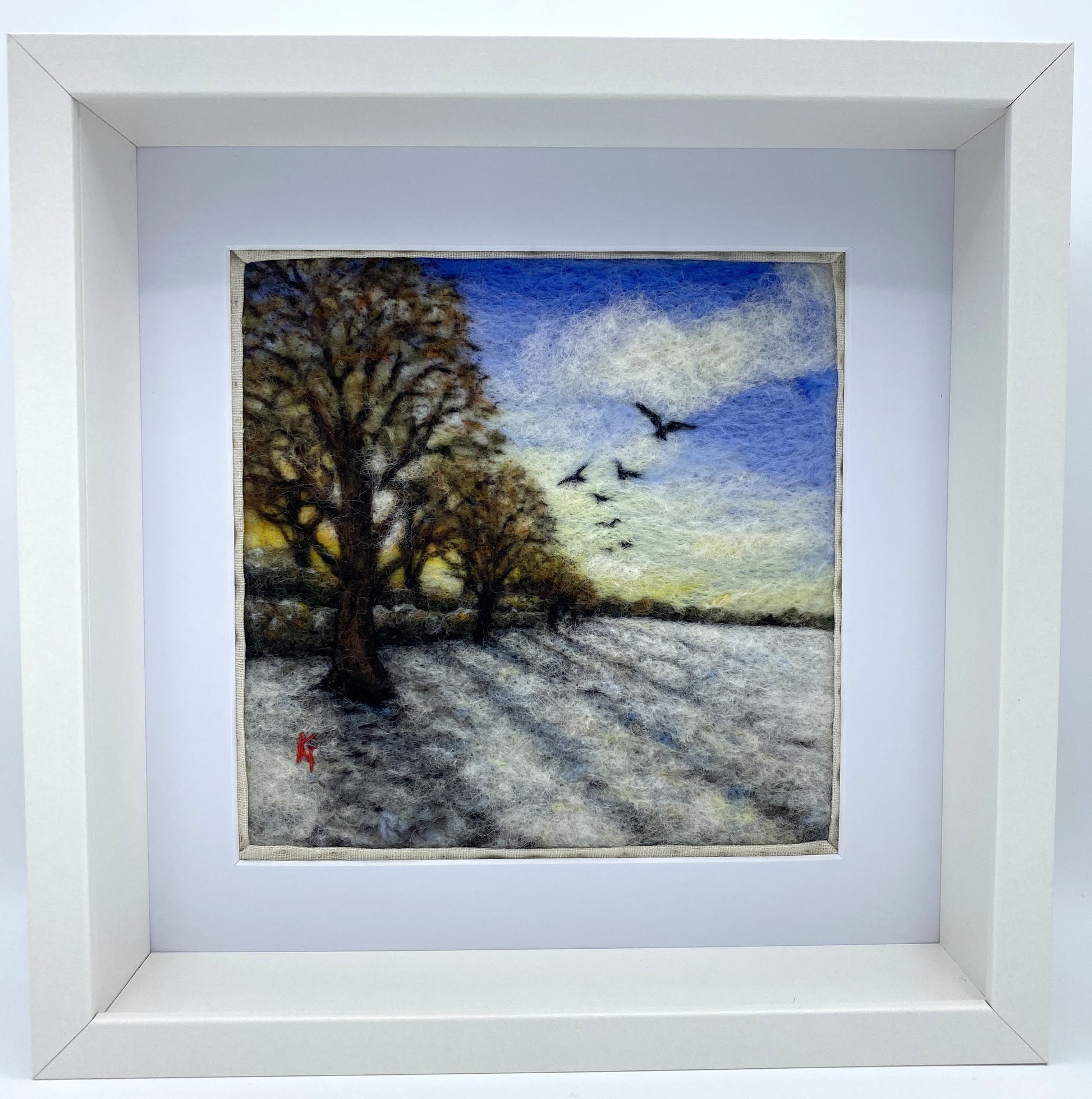 Needle felted depiction of the sun rising on a winters day