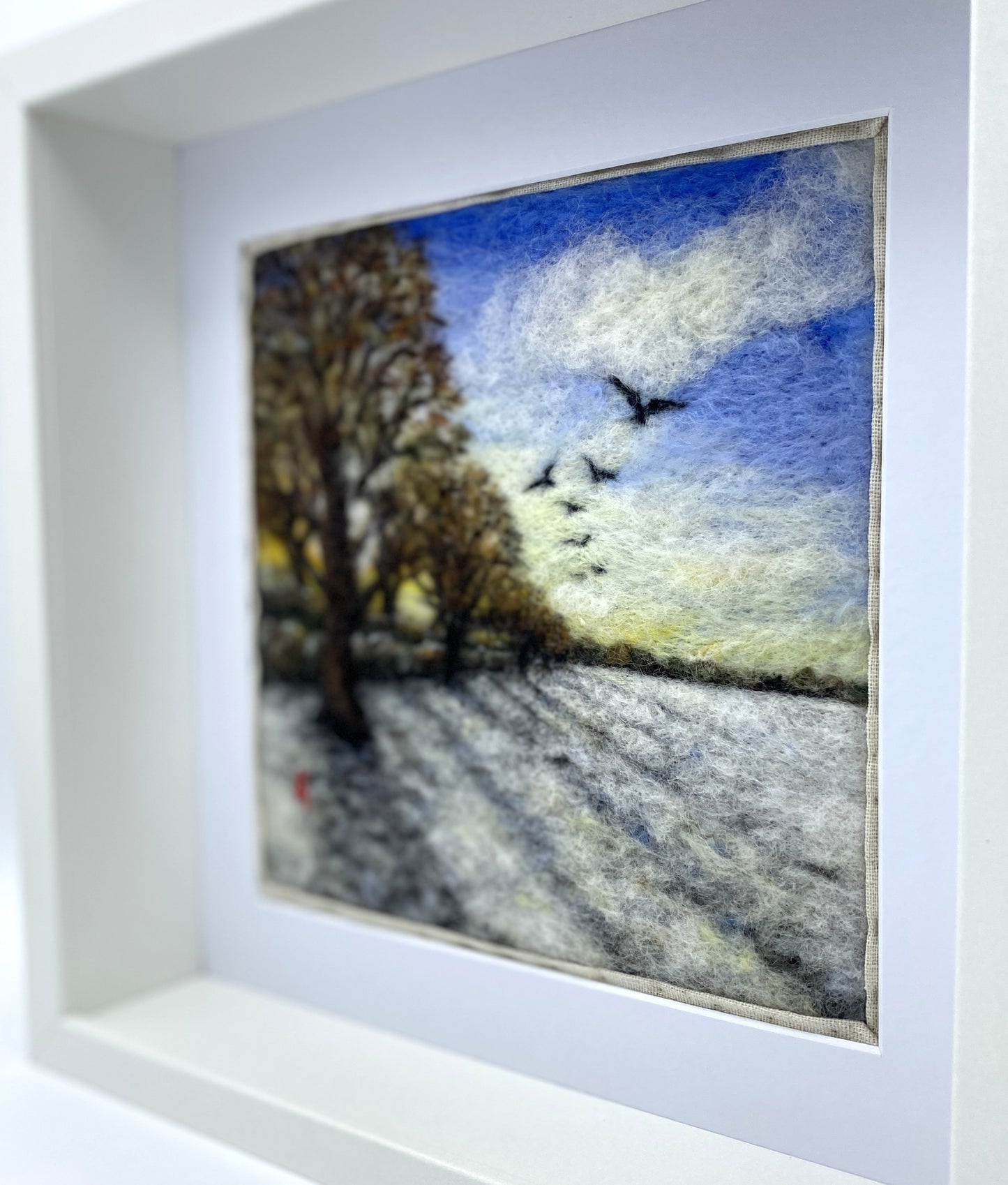 Needle felted depiction of the sun rising on a winters day