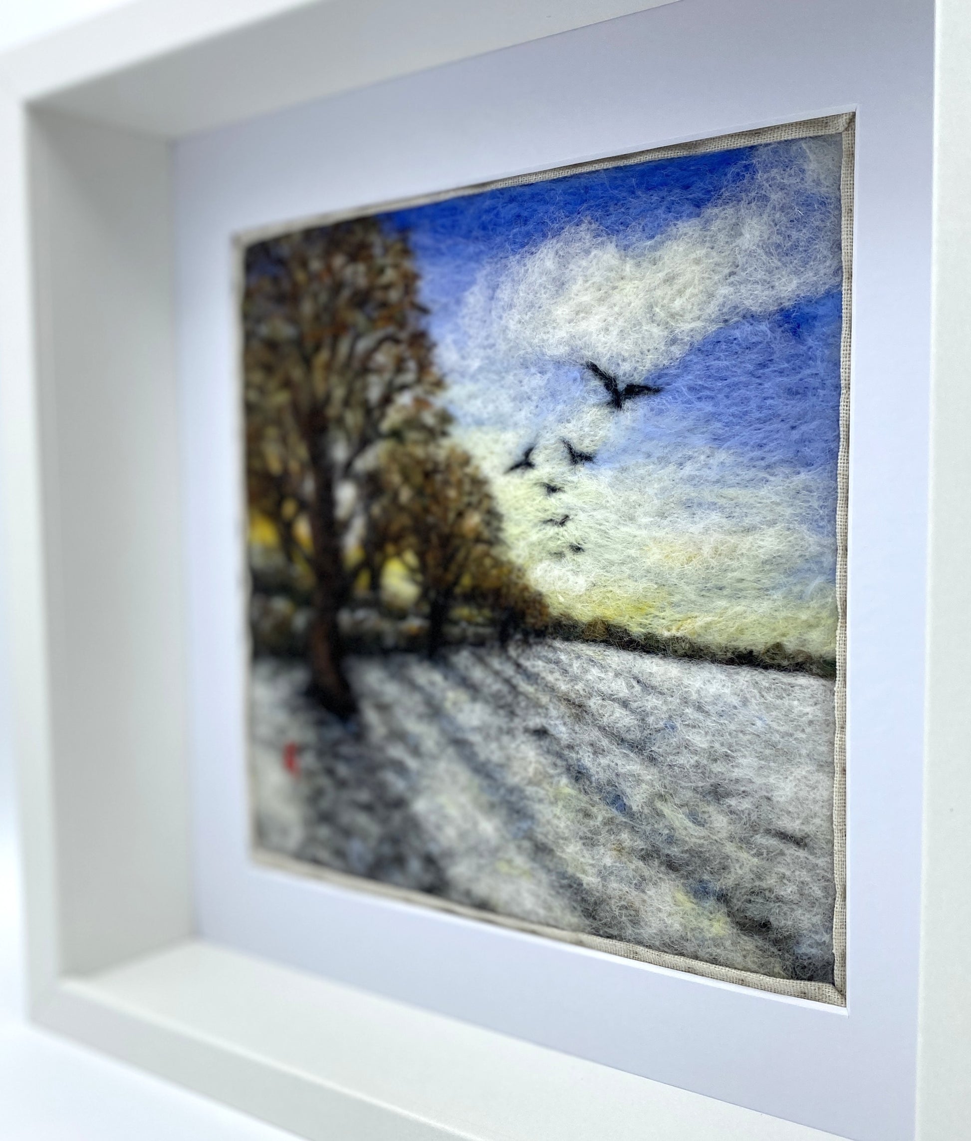 Needle felted depiction of the sun rising on a winters day