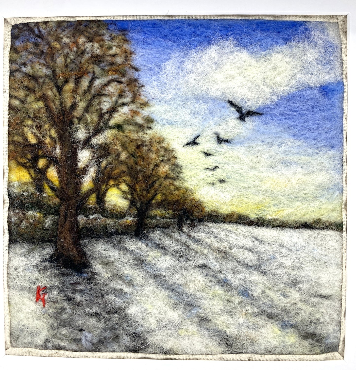 Needle felted depiction of the sun rising on a winters day