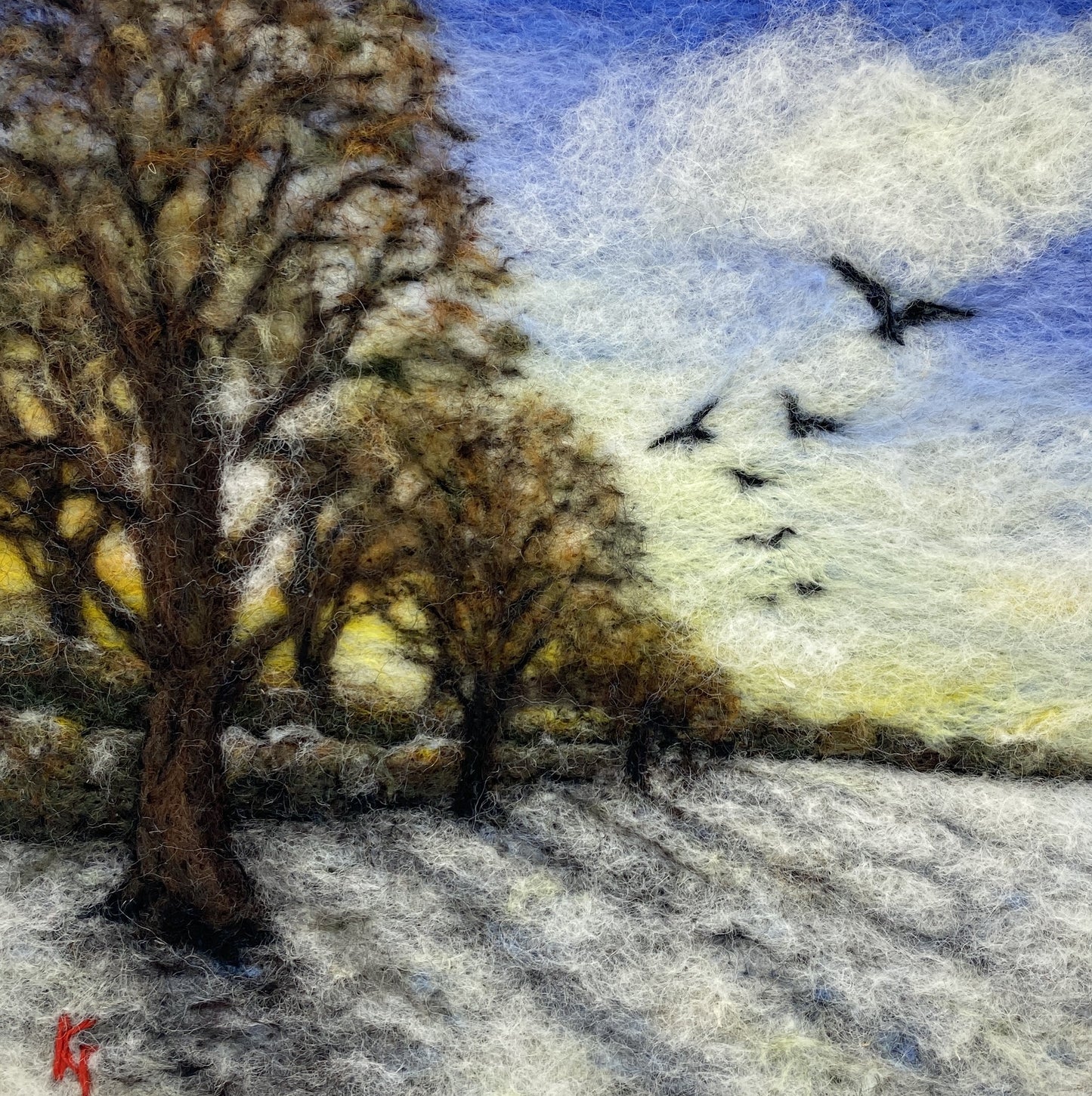 Needle felted depiction of the sun rising on a winters day