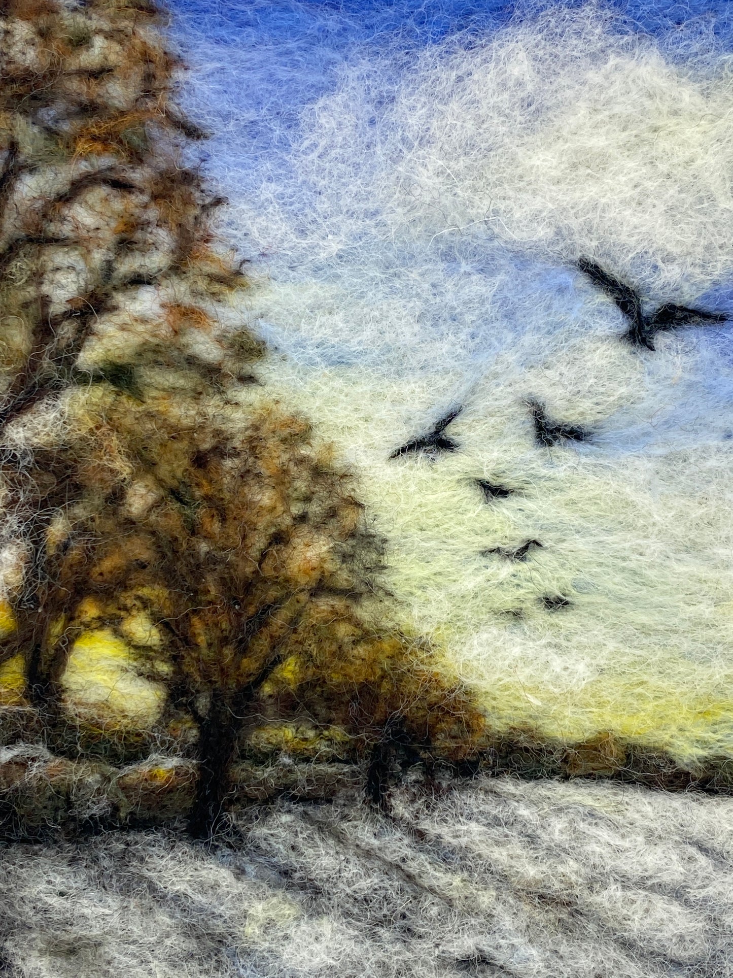Needle felted depiction of the sun rising on a winters day