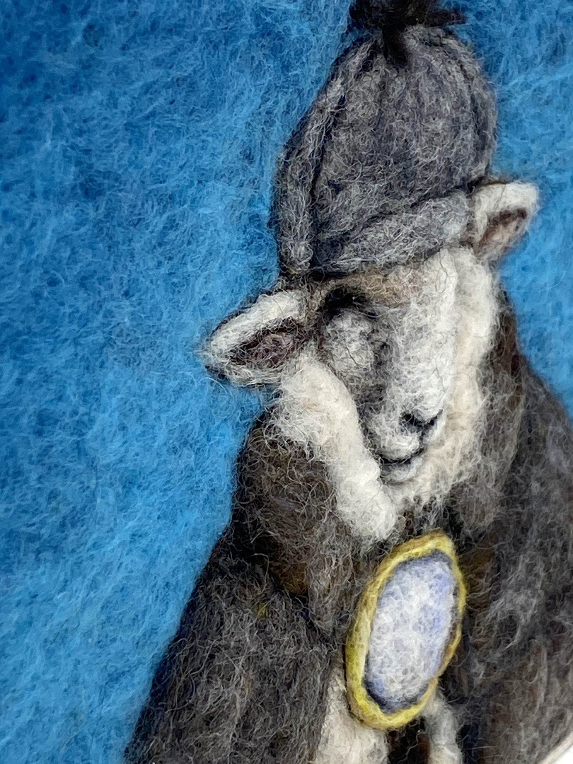 needle felted framed art work of a sheep dressed as Shelock Holmes in coat, deer stalker hat and holding a magnifying glass