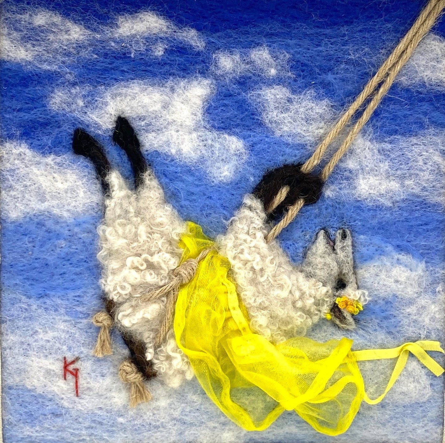 needle felted art work depicting a sheep on a swing wearing a yellow skirt