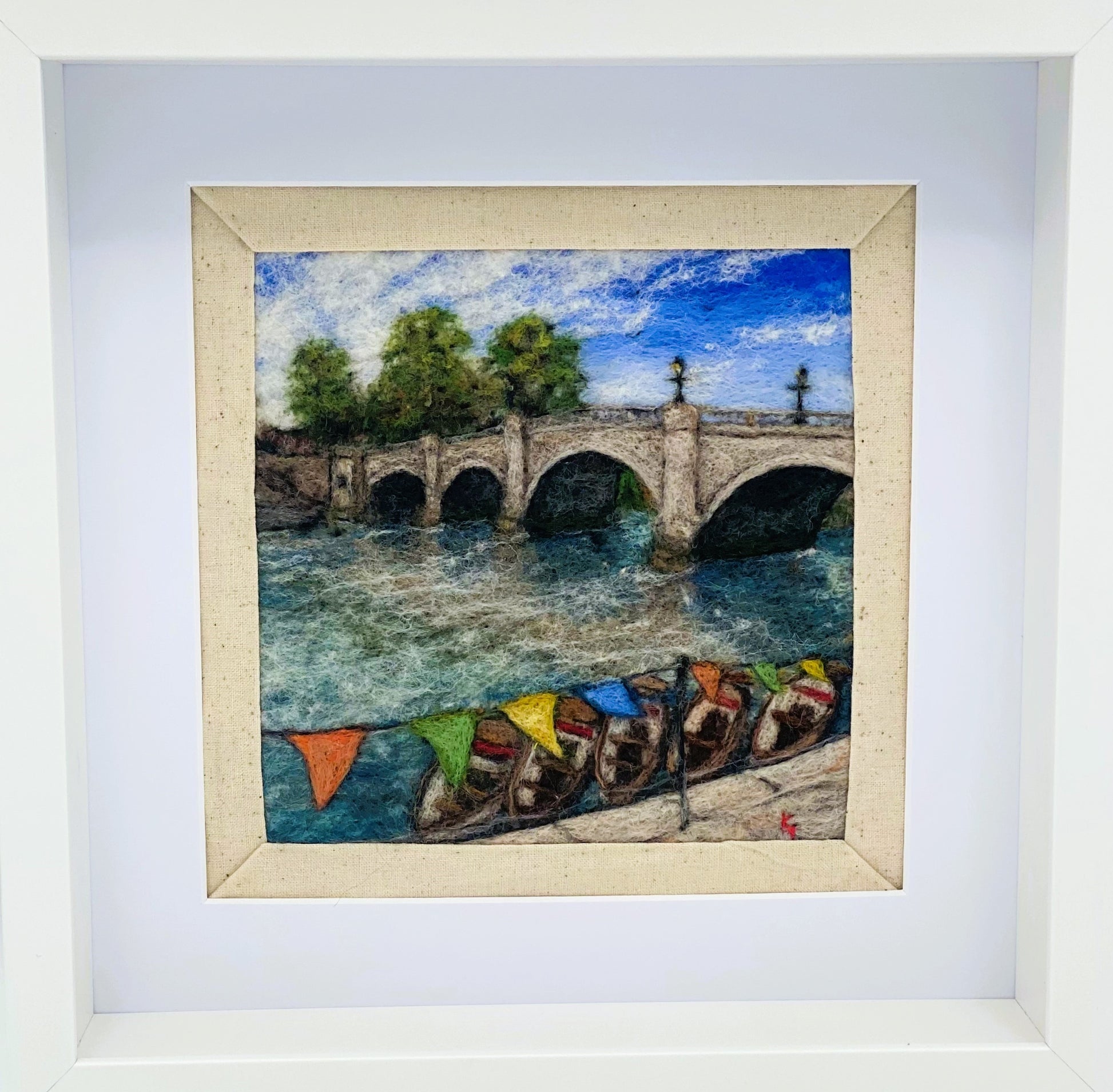 a box-framed, needle felted wool fibre picture of Ricmond Bridge showing the boats moared on the river, the bridge, trees, lamp posts and colourful bunting