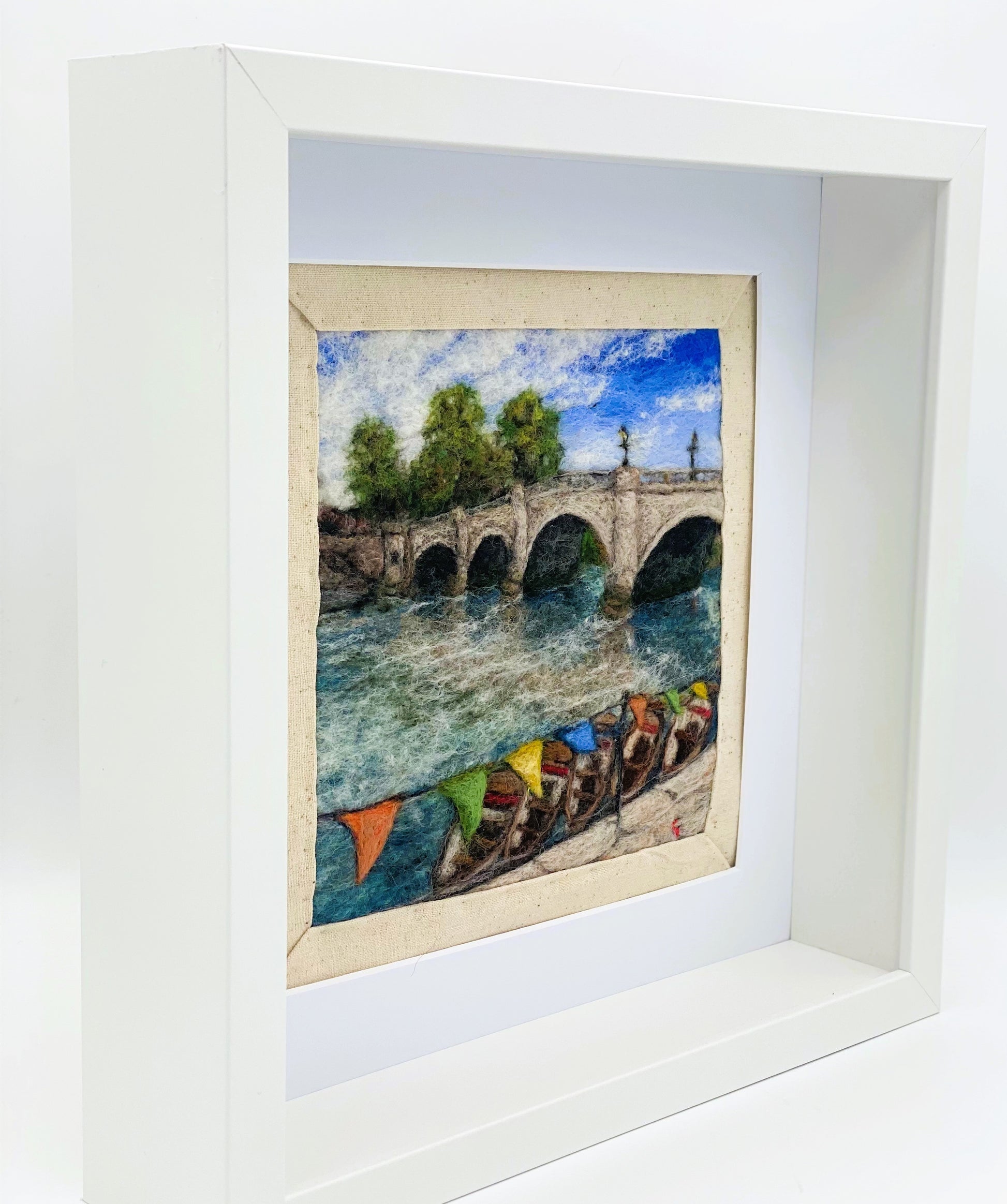 a box-framed, needle felted wool fibre picture of Ricmond Bridge showing the boats moared on the river, the bridge, trees, lamp posts and colourful bunting