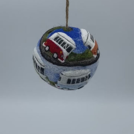 needle felted bauble depicting a convoy of seven VW style camper vans in a rainbow of colour, spiralling across the surface