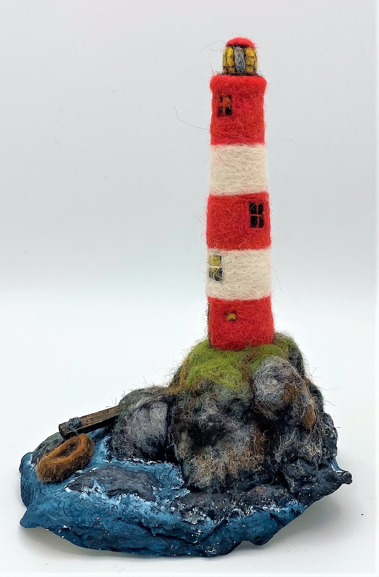 needle felted lighthouse, rocks, boat, jetty, path to front door, sea, grass, painted waves, on oyster shell base 